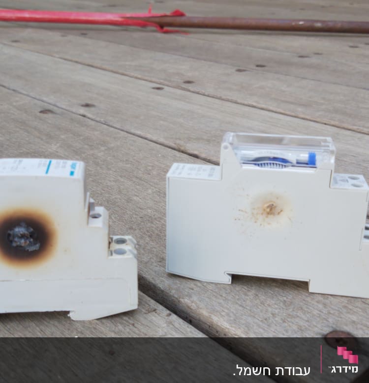 שני מפסקים חשמליים עם סימני שריפה על עץ